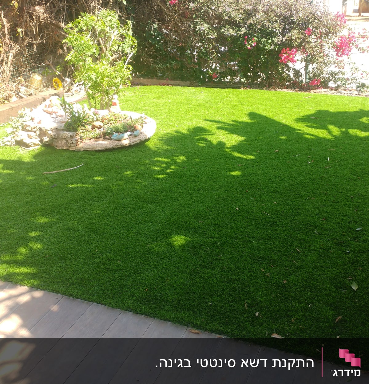 גינה עם דשא ירוק ועציץ עגול עם צמחים